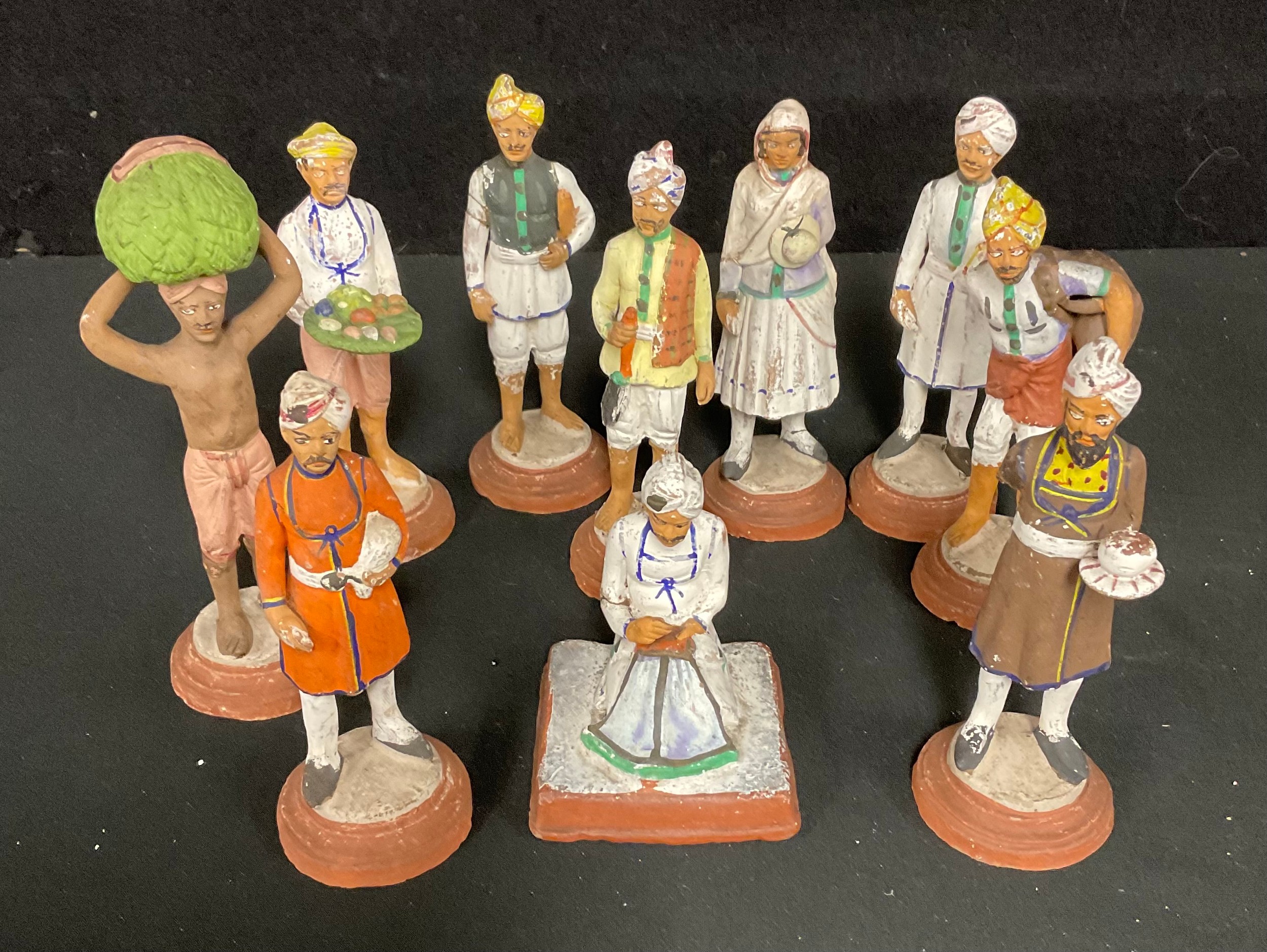 An Indian terracotta figure, servant with tray of fruit, hand painted, 13cm; others similar, scribe,