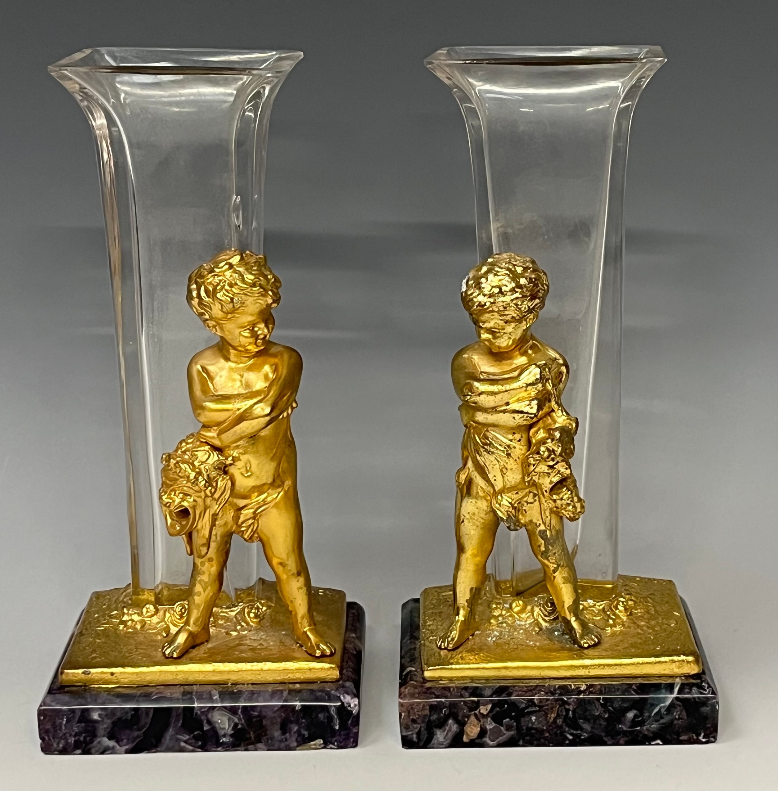 A pair of continental style vases, the gilt metal supports cast as a pair of putti holding Greek