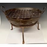 A round cast iron fire pit, tripod support, the pit 61cm wide, 48.5cm high over handles