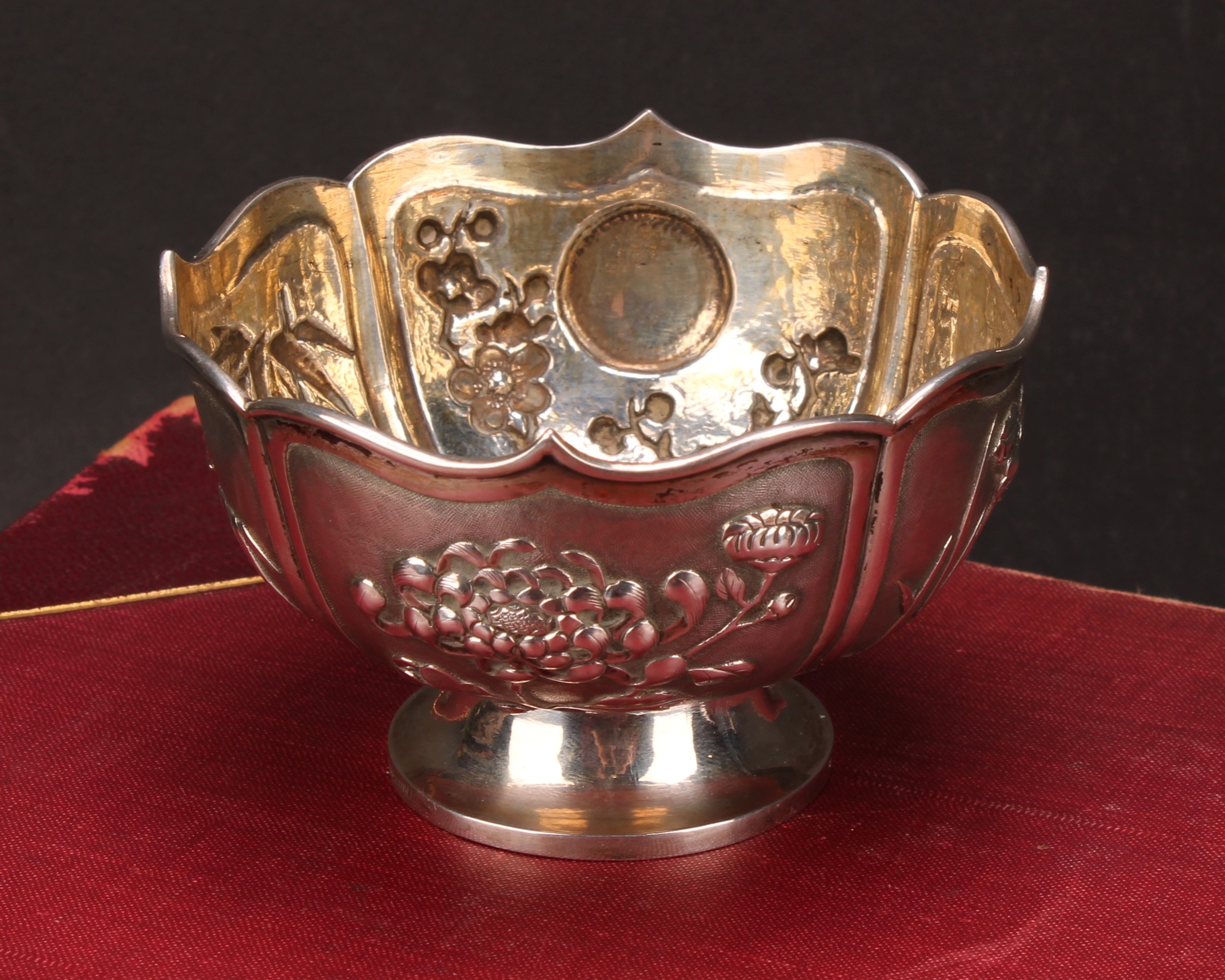 A Chinese silver lotus shaped pedestal bowl, applied with panels of chrysanthemums, bamboo, irises