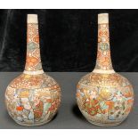 A pair of Japanese export ware Satsuma bottle vases, typically decorated with figures and