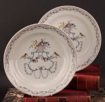 A pair of Delft chargers, painted in polychrome with birds, flowers and floral swags, 33cm diameter