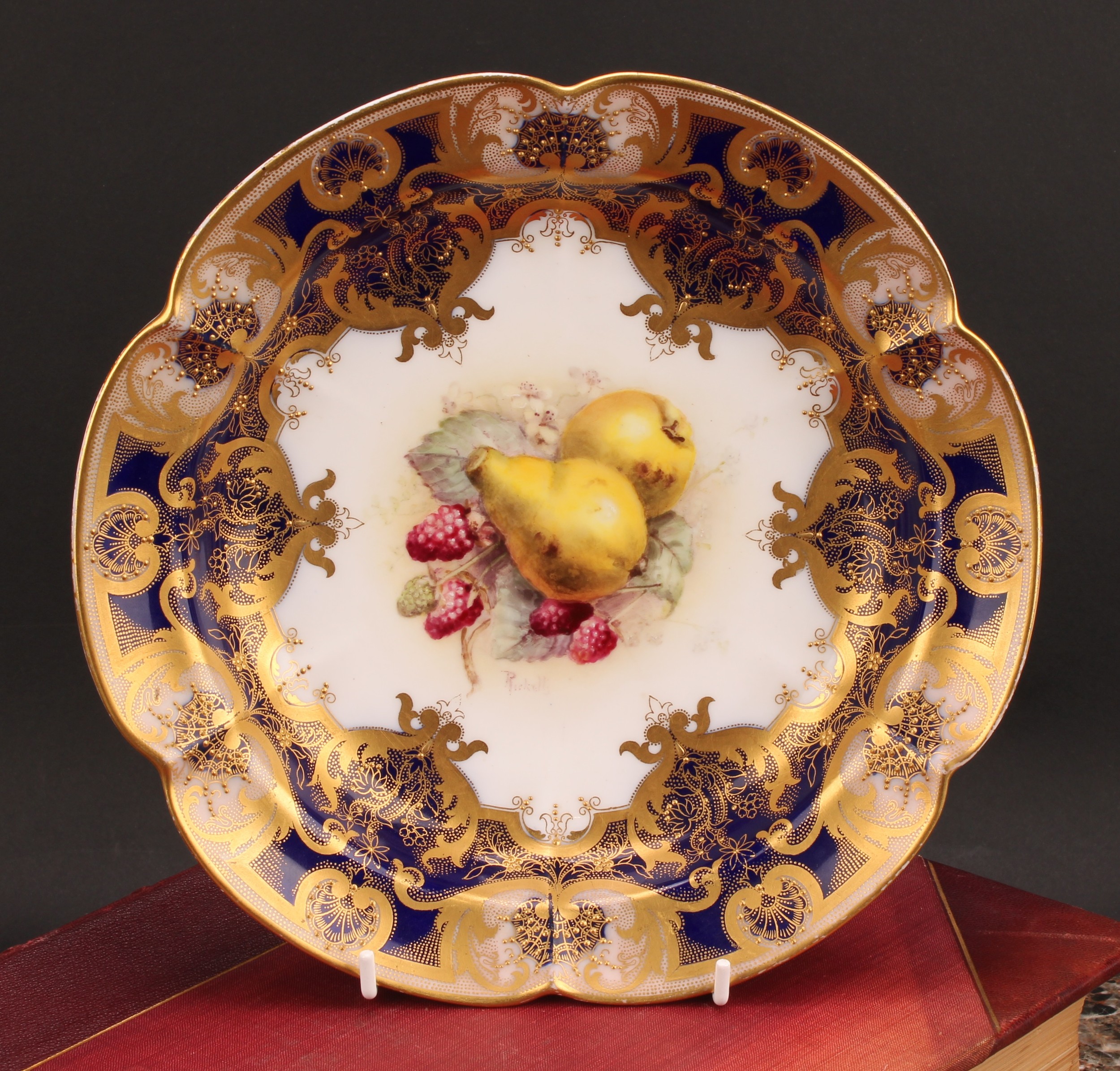 A Royal Worcester shaped circular dish, painted by Ricketts, signed, with ripening fruit within