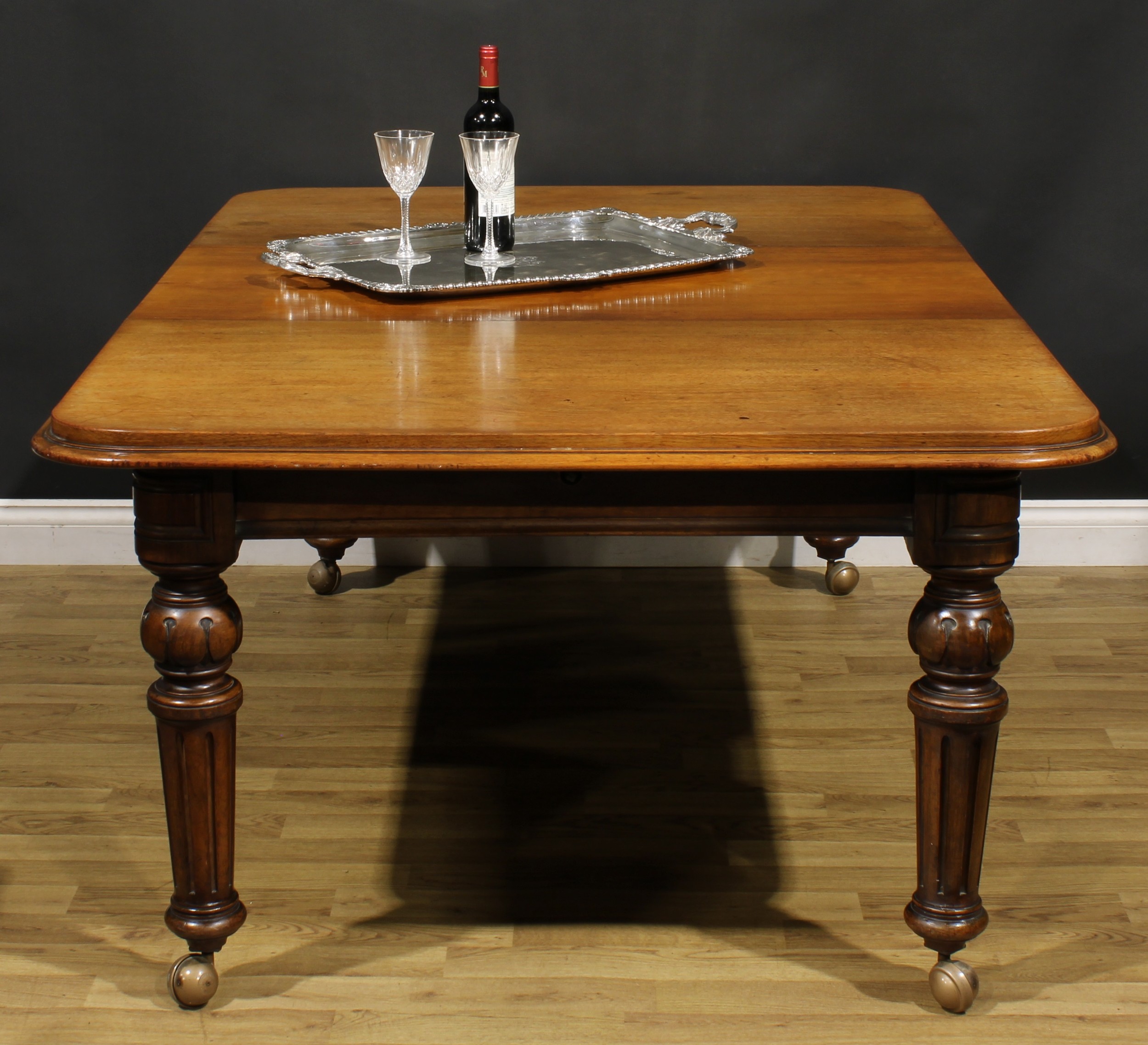 A Victorian walnut and mahogany extending dining table, rounded rectangular top with one