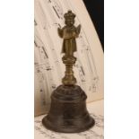 An Indian bronze and copper alloy hand bell, the haft cast as a Hanuman, the side chased with