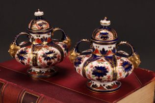 A pair of Royal Crown Derby Imari pattern compressed ovoid two-handled pedestal vases, domed covers,