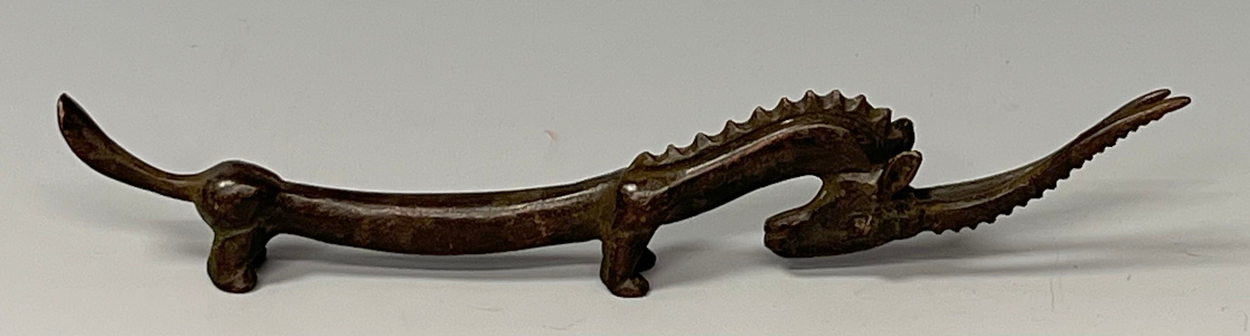 A bronzed metal figure of an elongated Gazelle, modelled in the Archaic taste, signed, 19cm long - Image 2 of 2