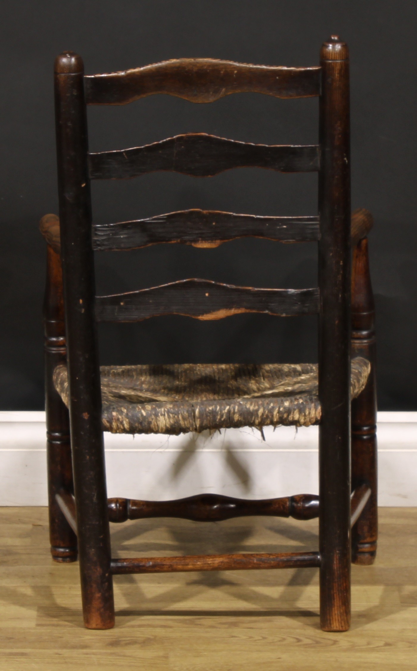 A 19th century elm child's chair, shaped ladder back, turned arms, legs and stretchers, rush seat, - Image 4 of 4
