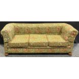 An early 20th century country house Chesterfield sofa, stuffed-over upholstery, squab cushions,