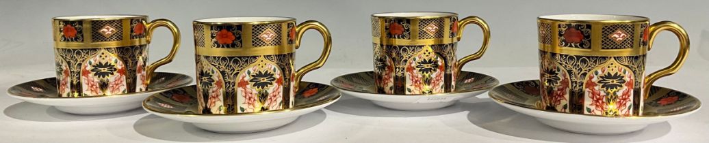A set of four Royal Crown Derby 1128 Old Imari pattern coffee cans and stands, solid gold band,