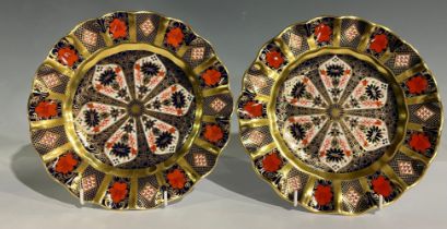A pair of Royal Crown Derby 1128 Old Imari pattern shaped circular plates, solid gold band, 22cm