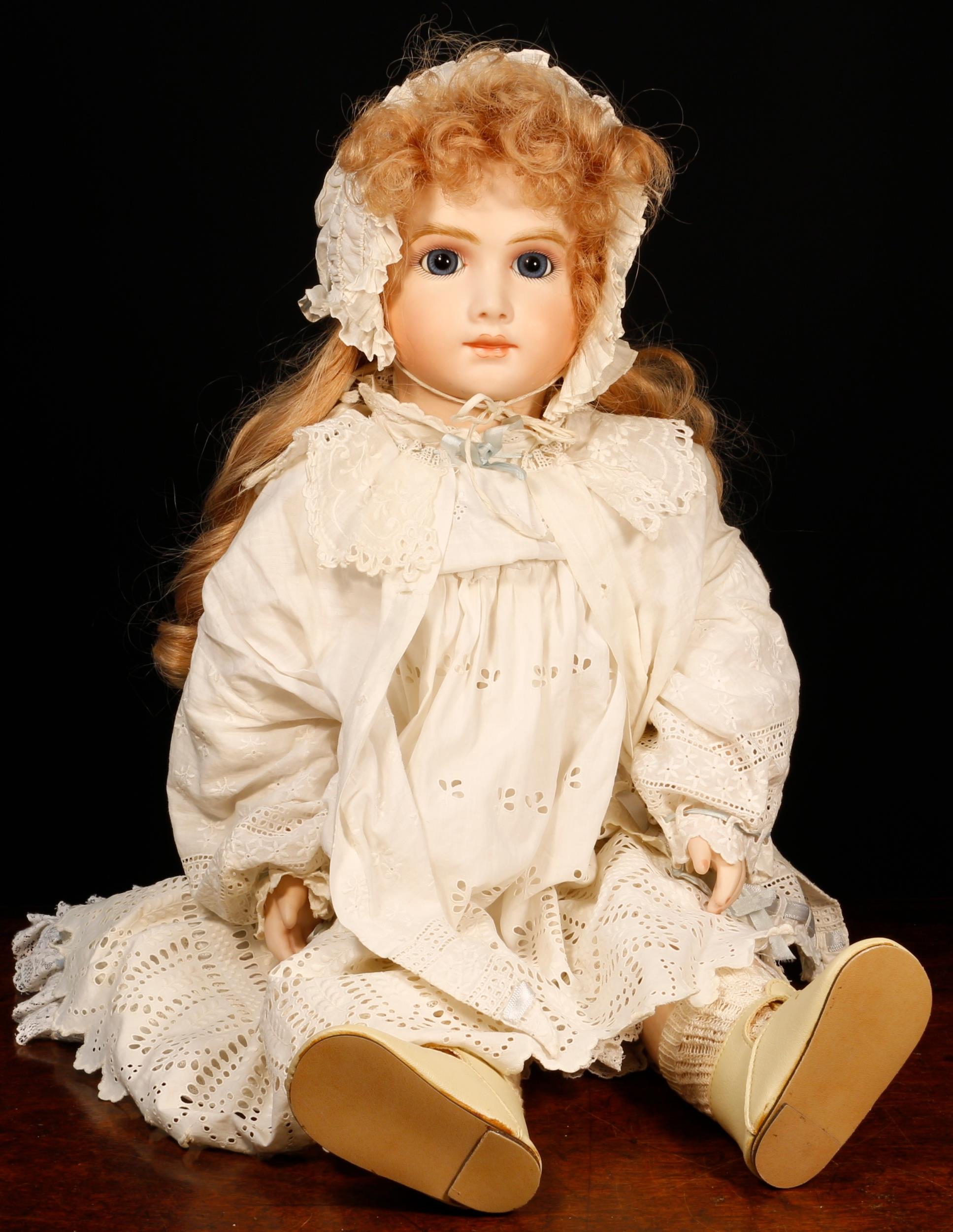 A reproduction bisque head doll, the bisque head inset with fixed blue glass eyes, painted