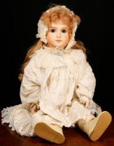 A reproduction bisque head doll, the bisque head inset with fixed blue glass eyes, painted