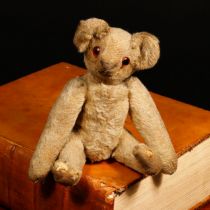 An early 20th century miniature golden mohair jointed teddy bear, amber and black glass eyes,