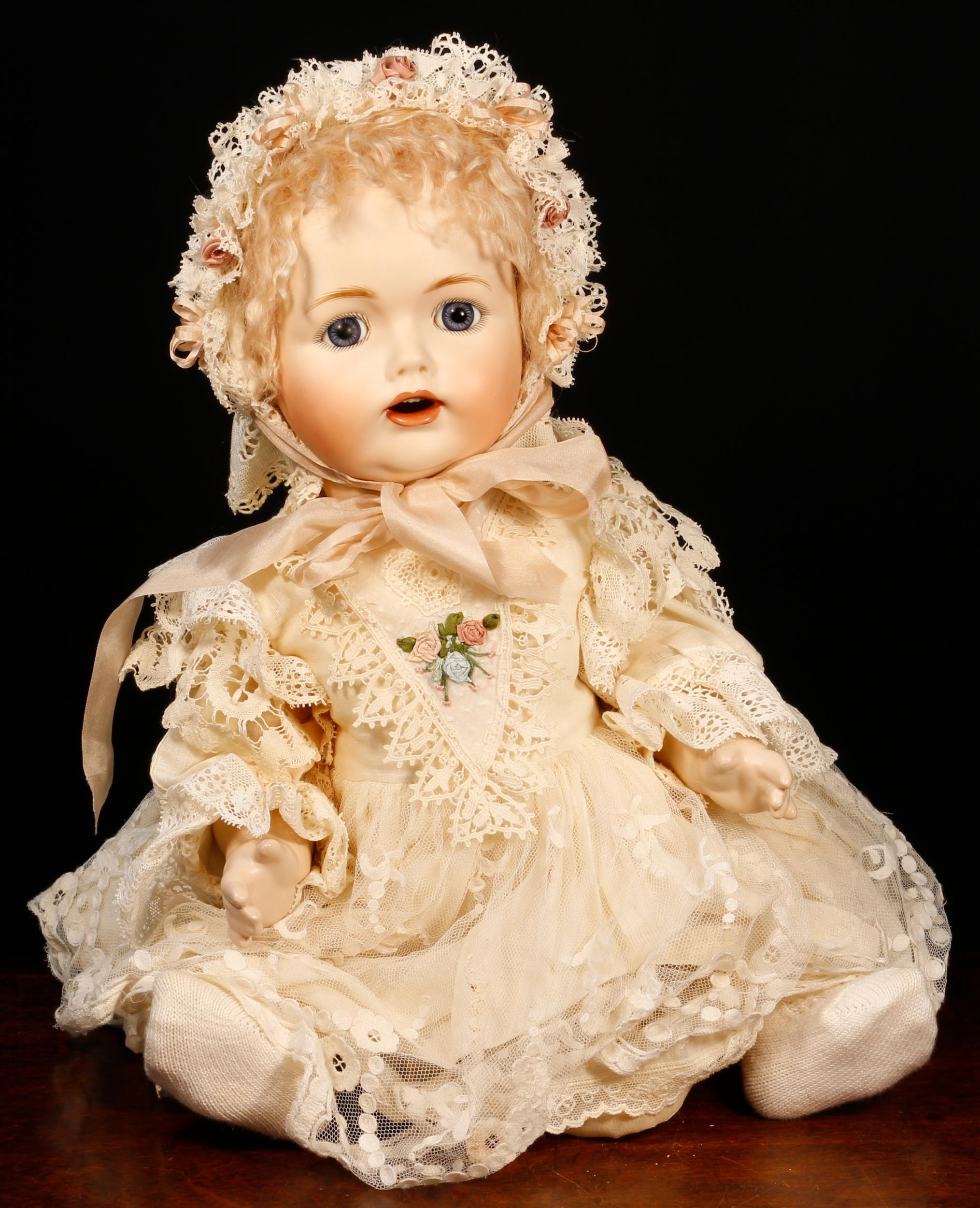 A reproduction bisque head and painted composition bodied doll, the bisque head inset with blue
