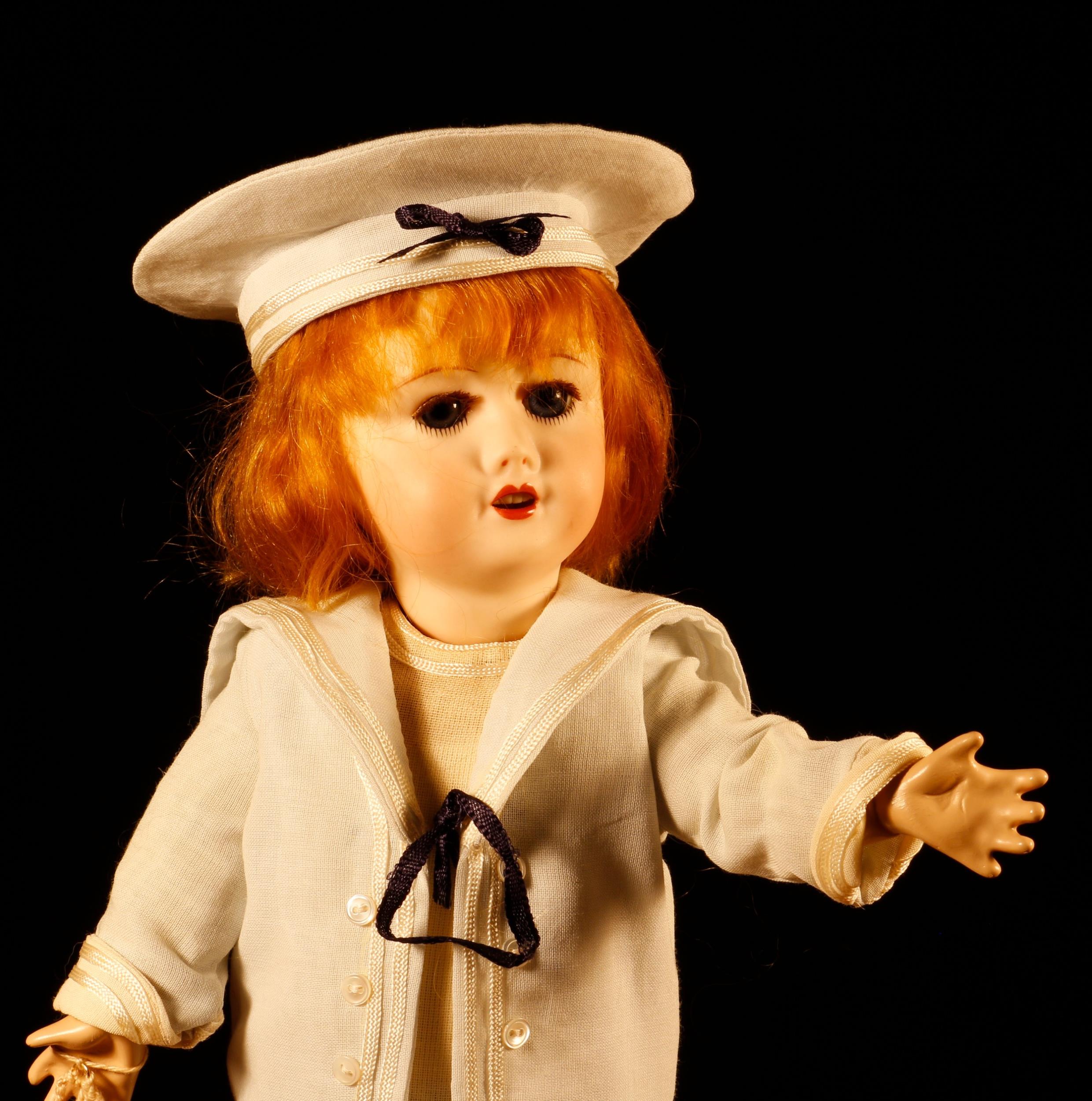 A reproduction bisque head doll, the bisque head inset with fixed blue glass eyes, painted - Image 2 of 2
