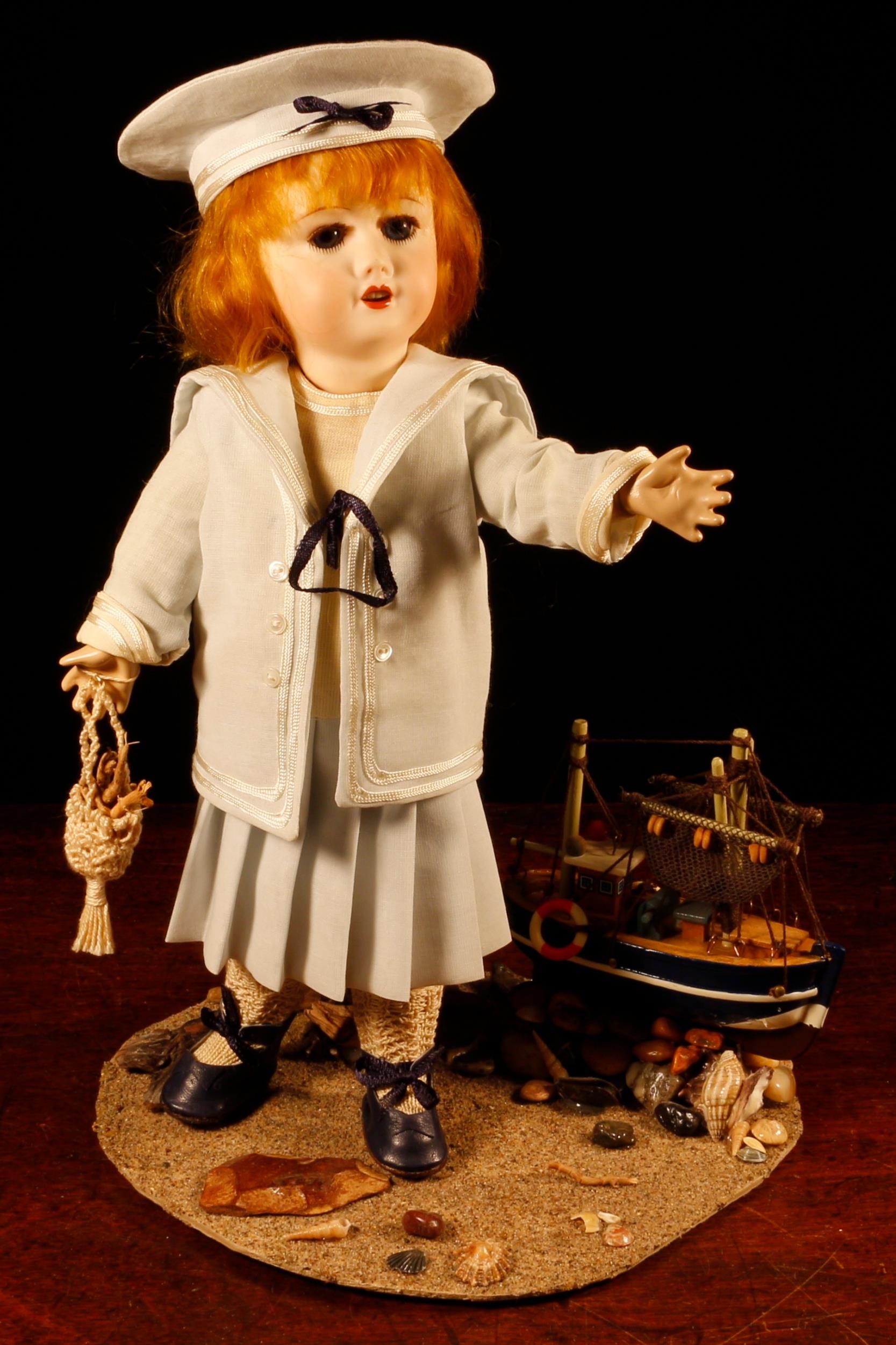 A reproduction bisque head doll, the bisque head inset with fixed blue glass eyes, painted