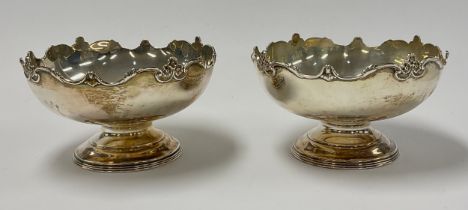 A pair of George V silver pedestal dishes, shaped rim chased with flowers and scrolls, 8cm high,