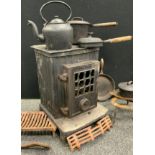 A Coalbrookdale cast iron wood burner stove, along with a cast iron kettle, three lidded pans, two