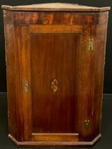 A George III oak corner cupboard, inlaid shell patera to the panelled door, enclosing three tiers of