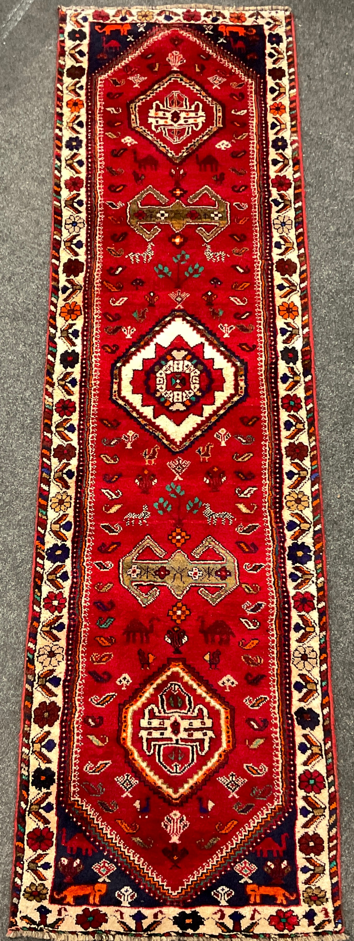A South-west Persian Qashgai runner carpet, hand-knotted in rich colours, with five medallions,