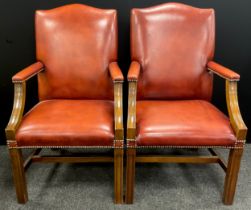 A pair of tan leather Gainsborough office chairs, 105cm high x 60cm wide; a footstool, (3).