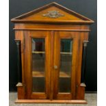 A small mahogany wall hanging display/specimen cabinet, shaped pediment above two bevelled glass