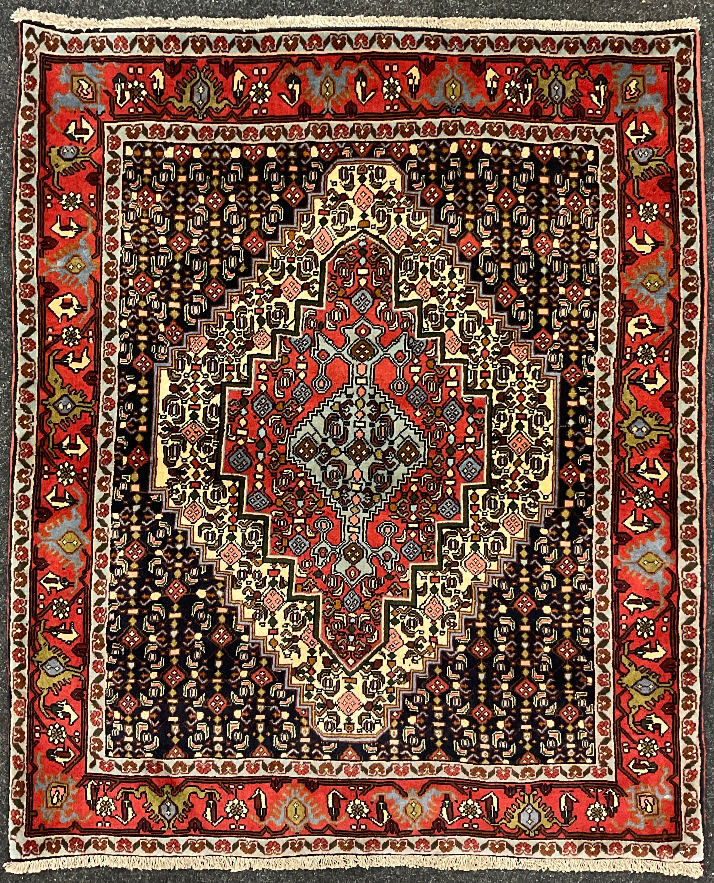 A North West Persian Senneh rug / carpet, hand-knotted with a central diamond-shaped medallion, in