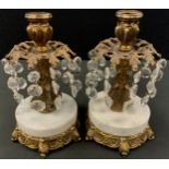 A pair of marble base gilt metal candlesticks, baroque decoration with branches of descending