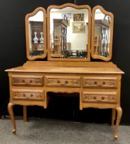 A French Provincial style oak dressing table, serpentine shaped triple mirror, above a base with