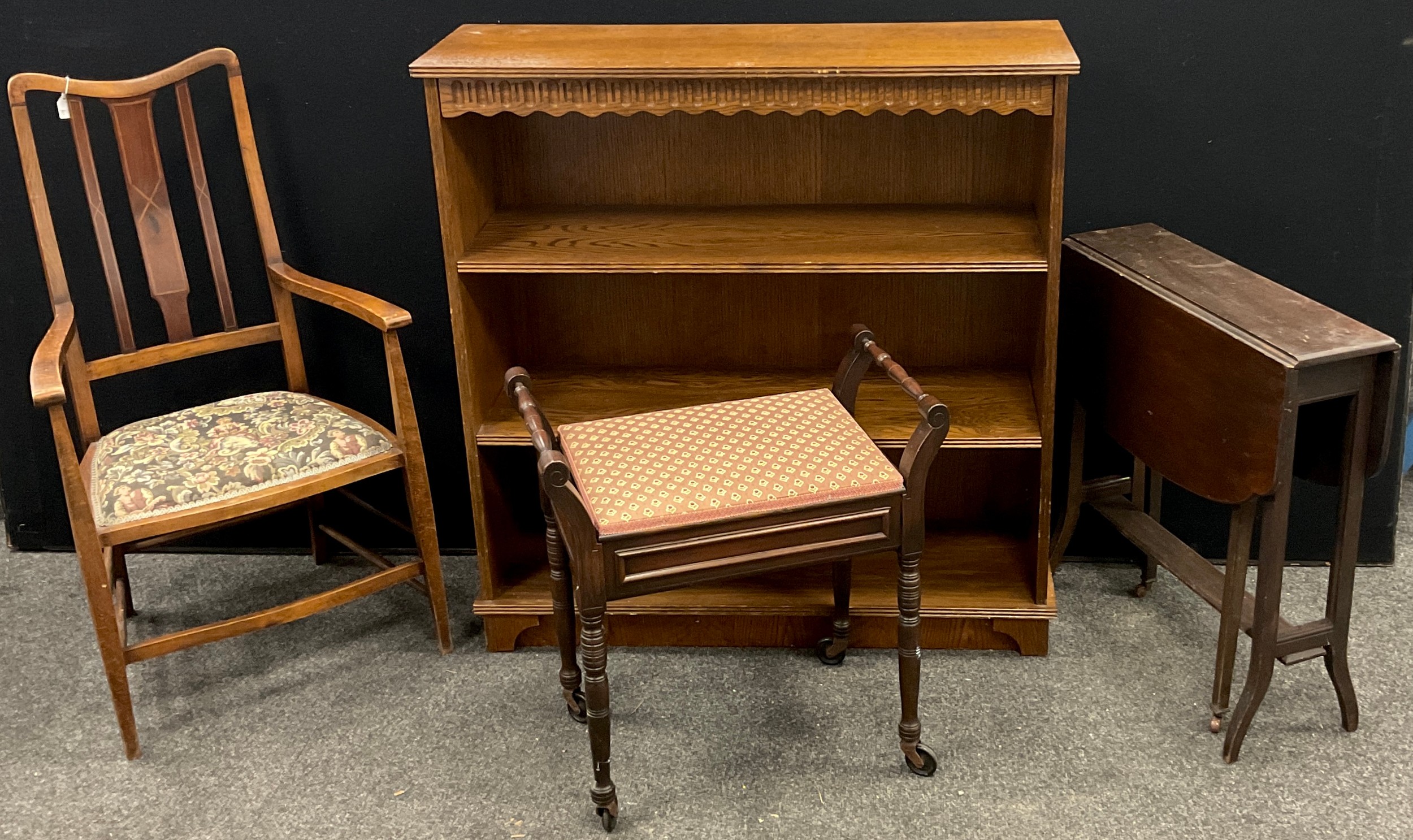 An Edwardian beech and walnut armchair; oak three tier open bookcase; piano seat; drop-leaf