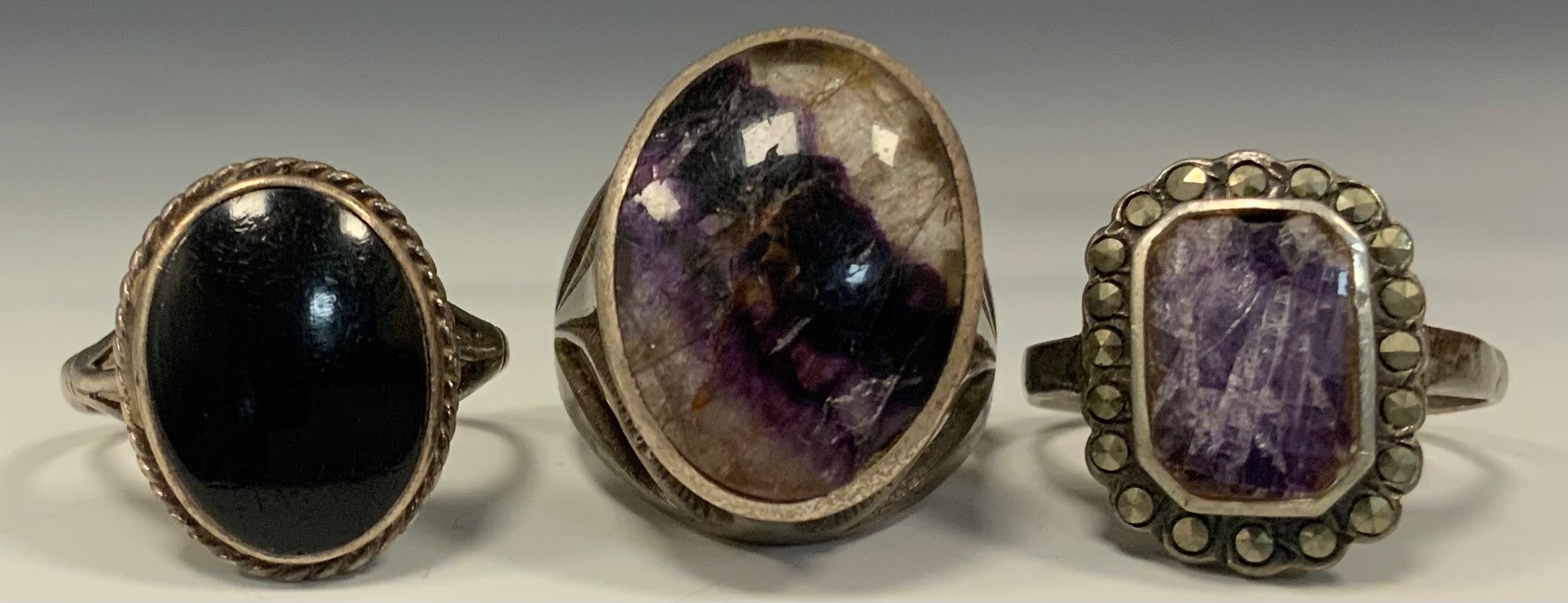 A blue john fluorite silver mounted oval cabochon ring, size N/M, another smaller, a black onyx