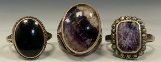 A blue john fluorite silver mounted oval cabochon ring, size N/M, another smaller, a black onyx