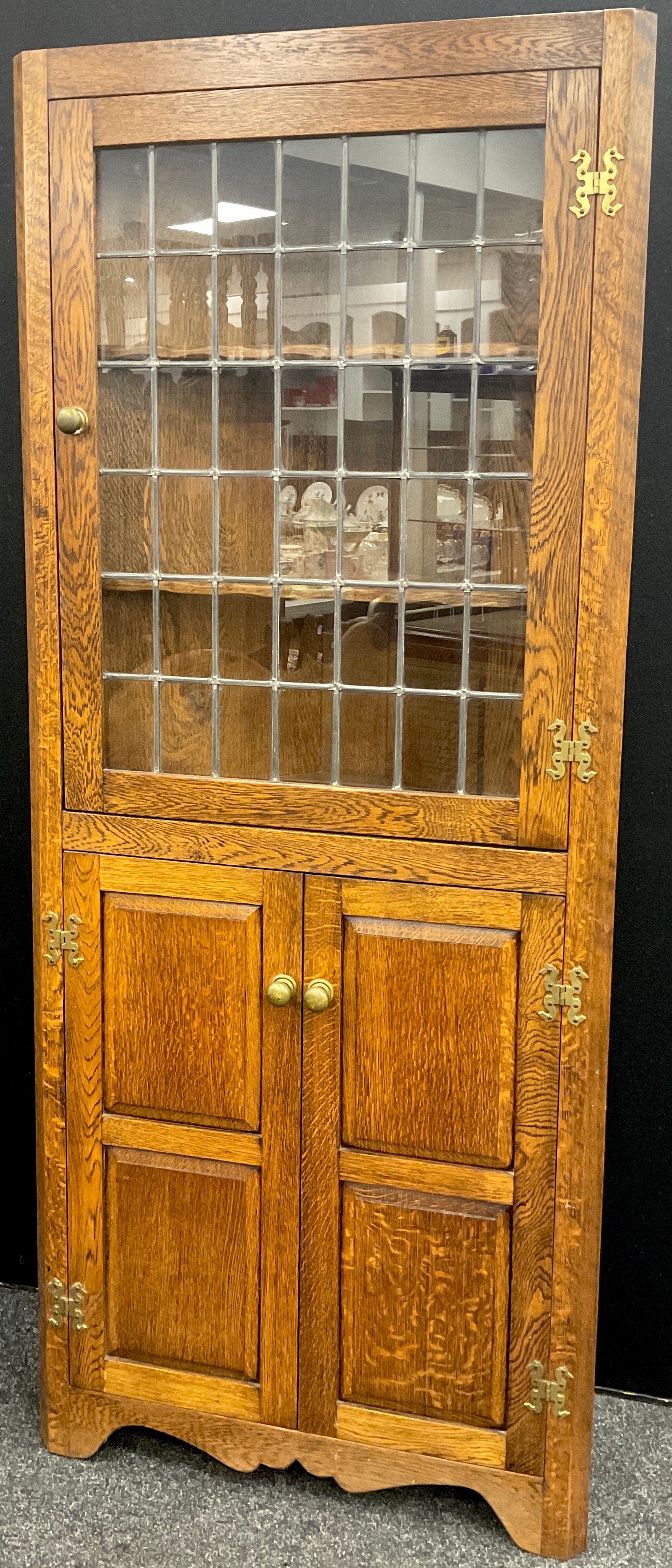 An oak floor-standing corner cabinet, by Andrew Sharpe furniture of Matlock, Derbyshire, 183cm