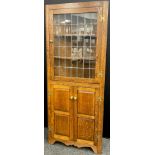 An oak floor-standing corner cabinet, by Andrew Sharpe furniture of Matlock, Derbyshire, 183cm