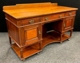 An early 20th century mahogany desk, quarter galleried top, three drawers to frieze, above a pair of