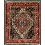 A North West Persian Senneh rug / carpet, hand-knotted with a central diamond-shaped medallion, in