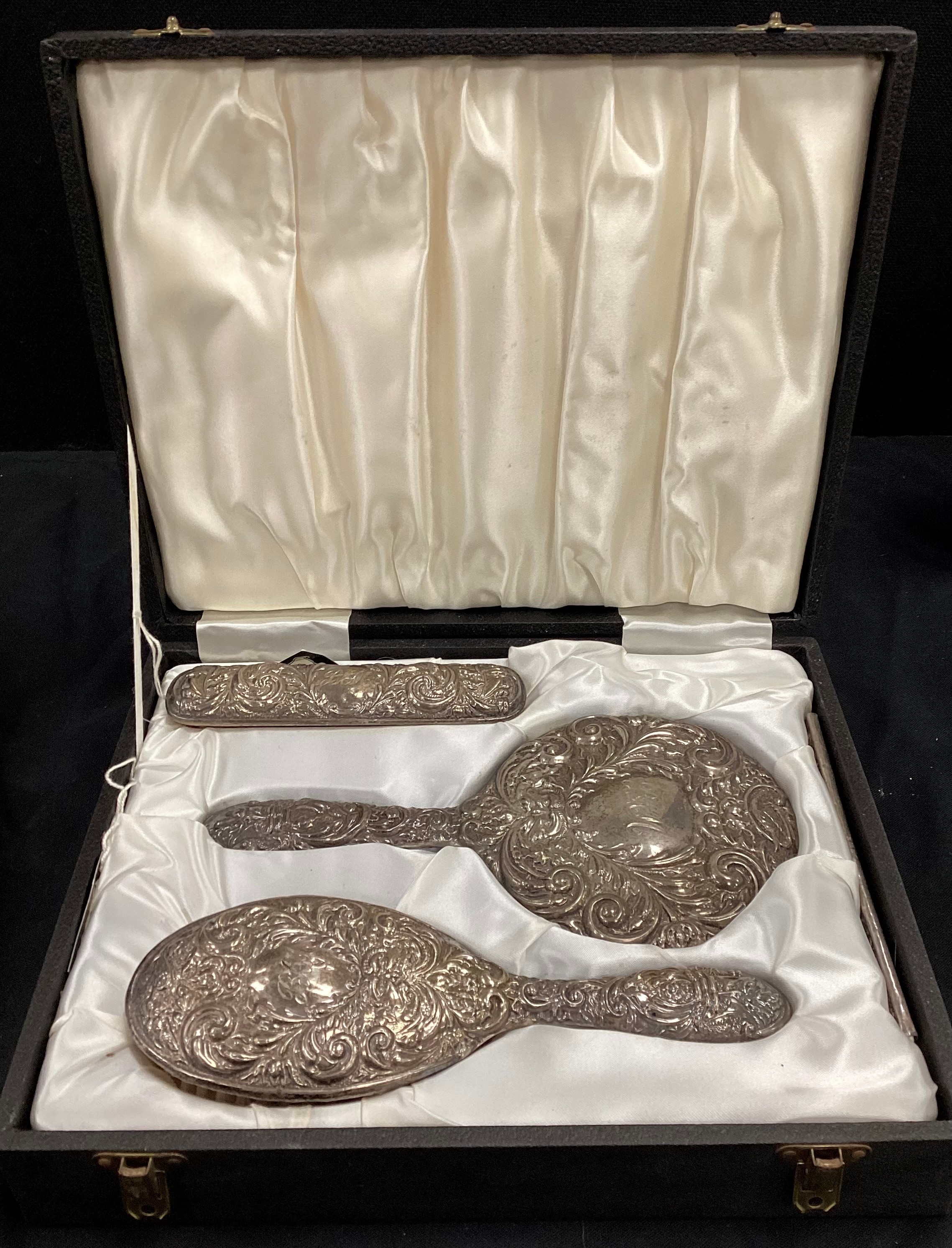 An Elizabeth II silver three piece dressing table set, Birmingham 1972, cased.