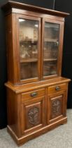 A late Victorian mahogany bookcase cabinet, out-swept cornice, above pair of glazed doors