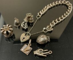 A 925 silver bracelet, padlock clasp, seven loose charms, crown, Acorn, bells, hand etc 46g gross; a