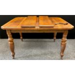 A Victorian oak extending dining table, the top with canted corners, two additional leaves, turned