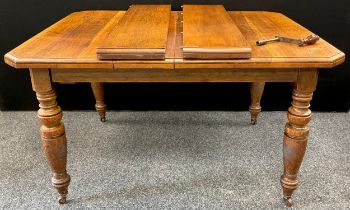A Victorian oak extending dining table, the top with canted corners, two additional leaves, turned