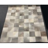 A contemporary cow hide rug or carpet, geometric patchwork design, 292cm x 237cm