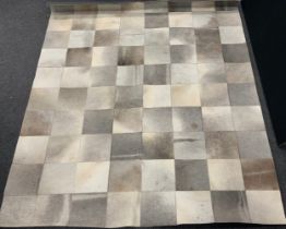 A contemporary cow hide rug or carpet, geometric patchwork design, 292cm x 237cm