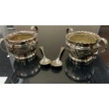 A cased pair of Edwardian silver twin handled table salts, clear glass liners, Birmingham 1904,