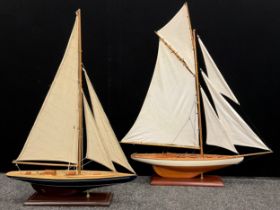 A model five-sail wooden yacht, 95cm high x 82cm long; another, smaller yacht, (2).