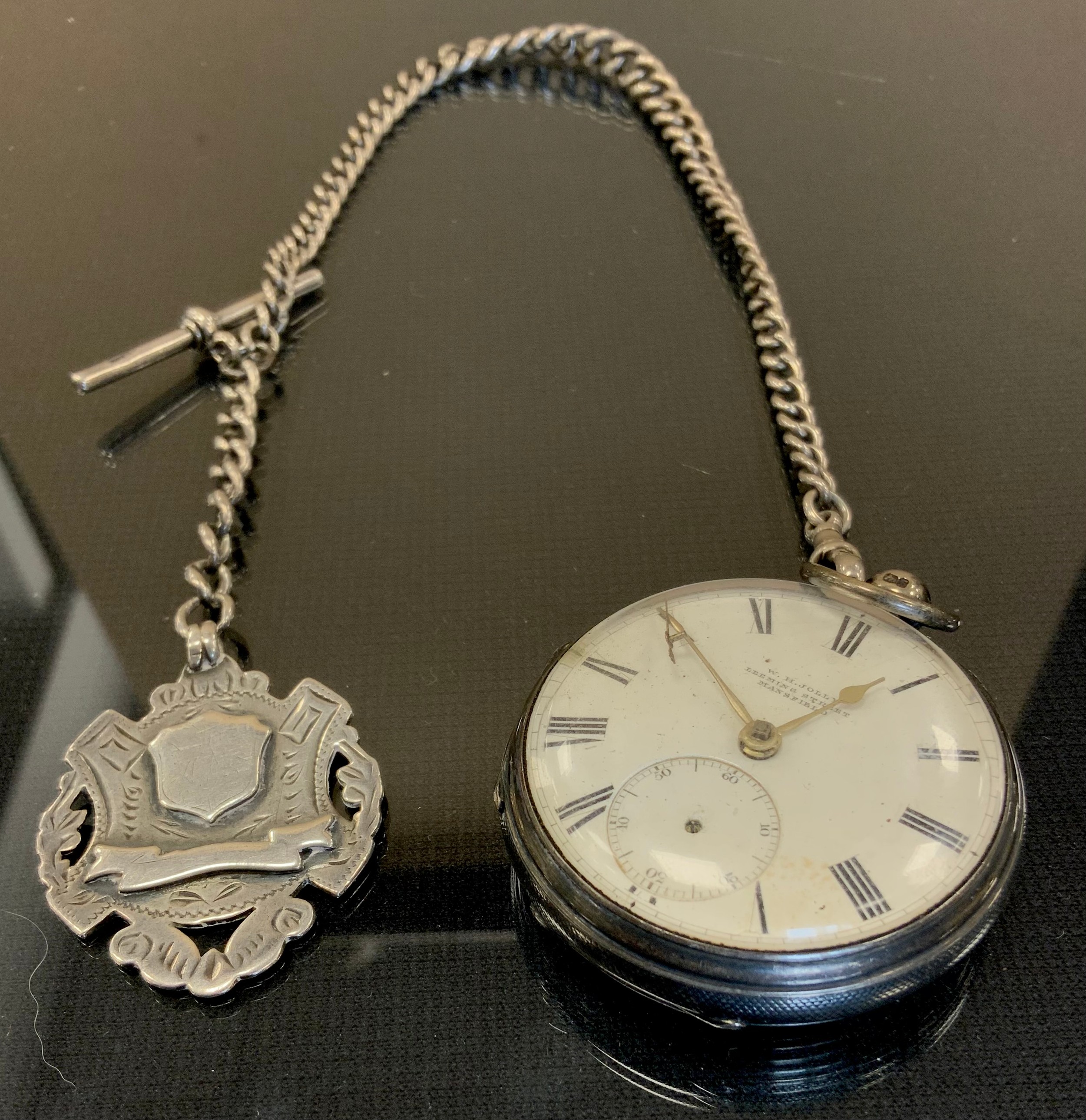 A Victorian silver open face pocket watch and silver Albert chain, white enamel dial, bold Roman