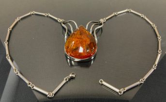 A silver and copal amber necklace, pear copal ridged cabochon, unmarked silver coloured metal