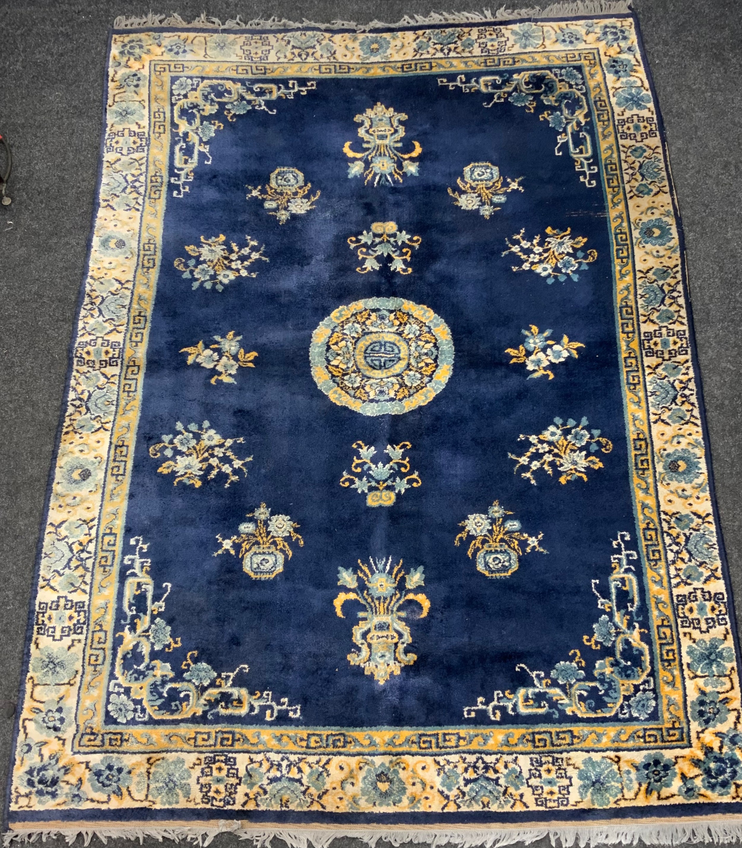 A Chinese silk and wool mix rug, central floral medallion within blue ground, stepped floral borders