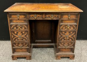 A Jacobean Revival oak kneehole desk, carved with strap work, 73cm high, 92cm wide, 50cm deep, c.